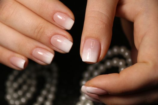 Closeup photo of a beautiful female hands with elegant manicure and diamond rings.