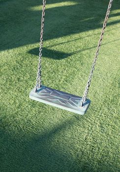 Empty swing on children playground,Children swing in the park,wooden swing,wooden swing with artificial grass