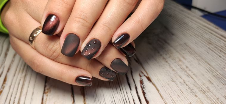 Glamorous luxurious brown crocodile manicure with gold plated women's nails closeup.