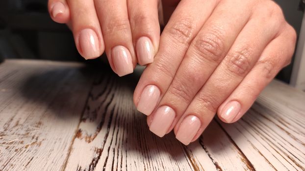 Hands with long artificial manicured nails colored with red nail polish