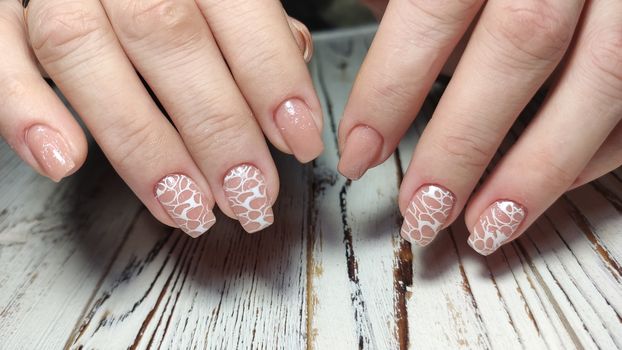 Hands with long artificial manicured nails colored with red nail polish