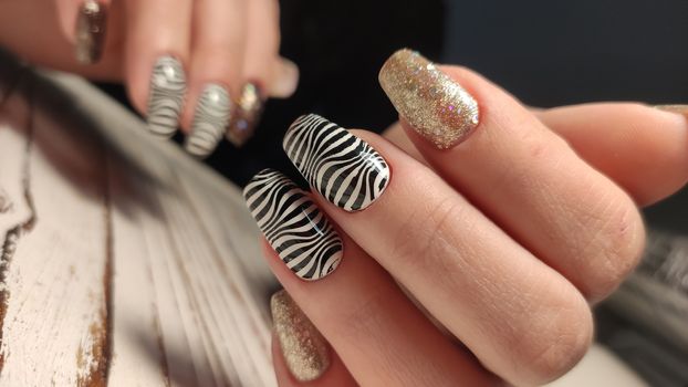 Hands with long artificial manicured nails colored with red nail polish