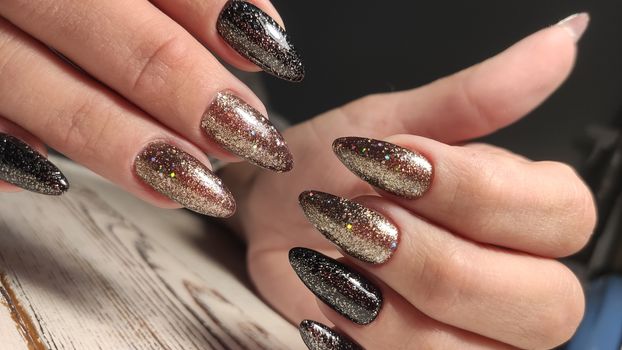 Closeup of hands of a young woman with dark red manicure on nails against white background