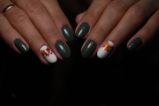 Closeup of hands of a young woman with dark red manicure on nails against white background