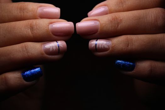 Closeup of hands of a young woman with dark red manicure on nails against white background