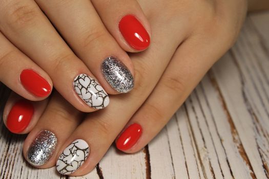 Hands with long artificial manicured nails colored with red nail polish