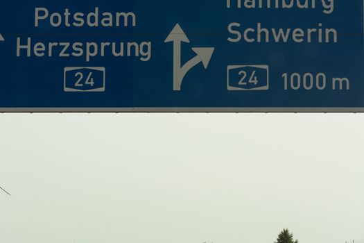 German motorway sign with inscription in German direction arrow to the cities - Berlin, Potsdam, Herzsprung, Hamburg and Schwerin