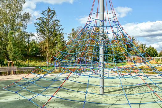 Jungle gym exercise equipment made of metal and ropes in a playground