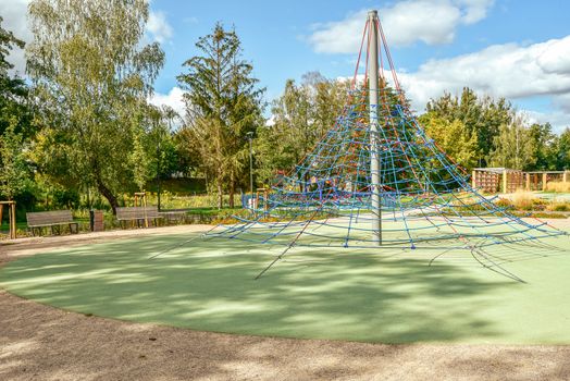 Jungle gym exercise equipment made of metal and ropes in a playground
