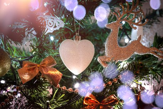 Christmas decoration hanging on a tree covered with snow. Focus on a decoration.