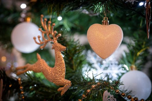 Christmas decoration hanging on a tree covered with snow. Focus on a decoration.