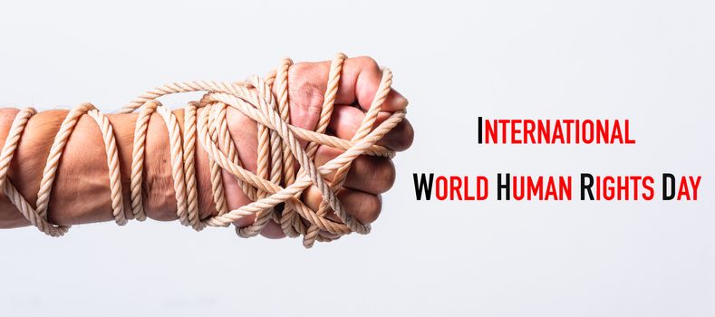 Rope on fist hand with international World HUMAN RIGHTS DAY text on white background, Human rights day concept