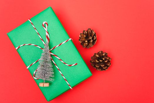 New Year, Christmas Xmas holiday composition, Top view green gift box and green fir tree branch on red background