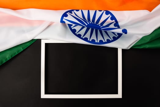 Indian republic day, flat lay top view, Indian flag and photo frame on black background with copy space for your text