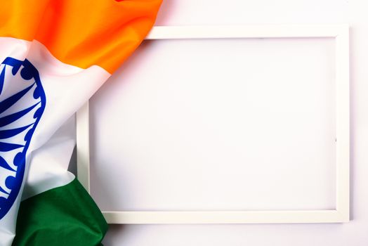 Indian republic day, flat lay top view, Indian tricolor flag and photo frame on white background with copy space for your text