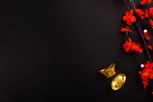 Chinese New Year, flat lay top view, gold bar and Chinese Flower on black background with copy space for your text