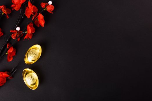 Chinese New Year, flat lay top view, gold bar and Chinese Flower on black background with copy space for your text