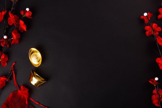 Chinese New Year, flat lay top view, gold bar and Chinese Flower on black background with copy space for your text