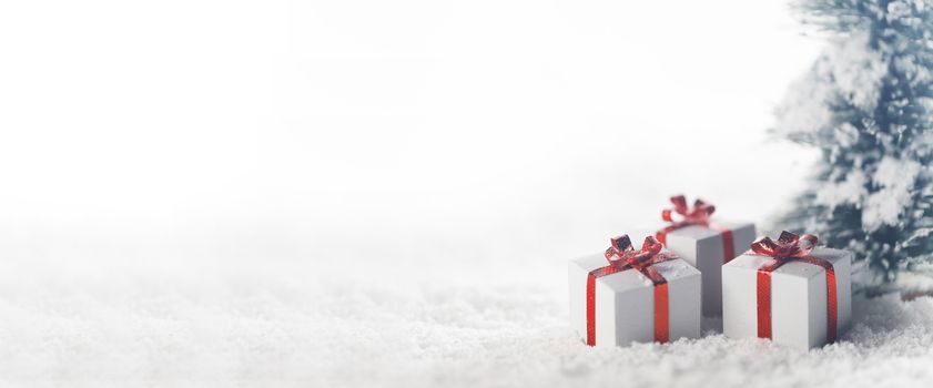 Christmas tree and gift boxes on snow isolated on white background