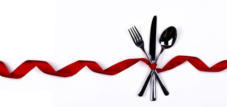 Cutlery set tied with silk red ribbon isolated on white background Valentine day dinner concept