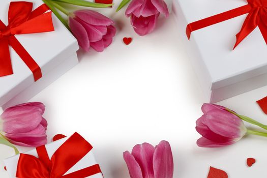 Pink tulip flowers gifts and red hearts composition on white background top view with copy space. Valentine's day, birthday, wedding, Mother's day concept. Copy space