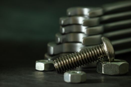 Bolt nuts and wrench on cement floor in darkness. Closeup and copy space for text. Concept of mechanical engineering jobs.