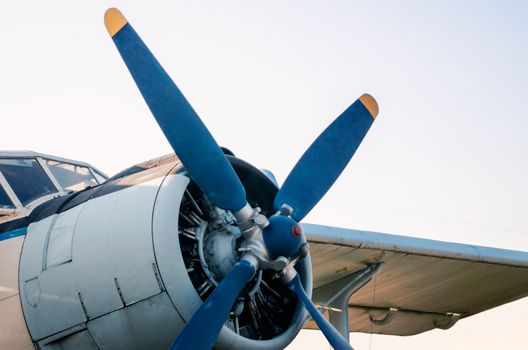 pilot cabin propeller and wing of an old vintage airplane isolated on blue sky background