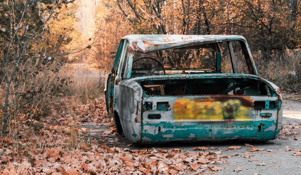 abandoned broken rusty car with no wheels on Chernobyl street