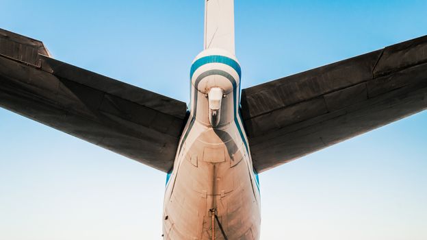 tail and wings of a large old airliner against a blue sky