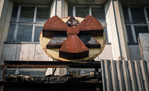 old rusty radioactive symbol on the facade of a building in Chernobyl close up