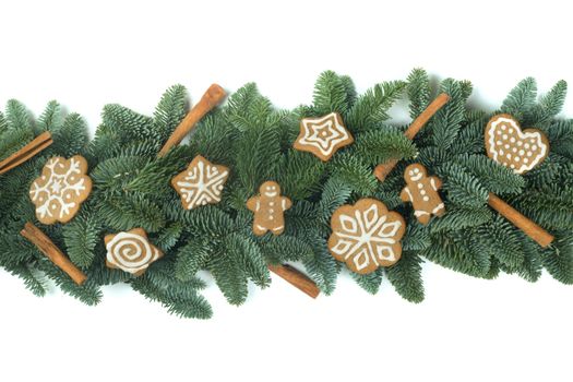 Christmas Border frame of natural noble fir tree branches and gingerbread cookies isolated on white background