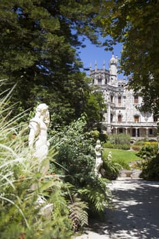 Quinta da Regaleira on  abright sunny day with blooming flowers in front.