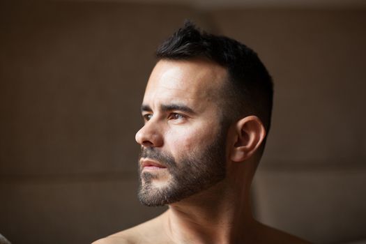 Confident dark-haired man in profile looking aside