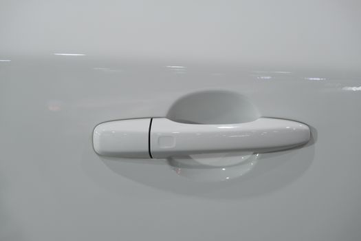 The Handle of the door of a luxury white car