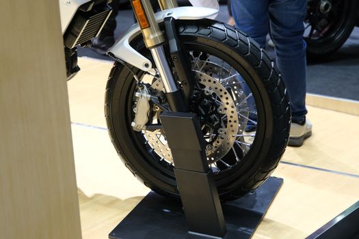 The Closeup of new motorbike rear wheel . Big bike parked in showroom of dealership