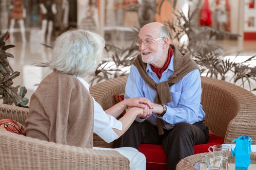 Senior Couple holding hands and talking about love in cafe Valentines day concept