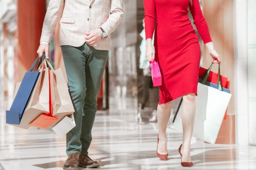 Young elegant couple walking with shopping bags in store