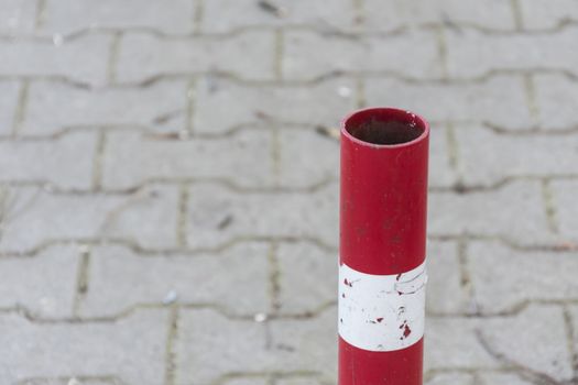 Traffic pole on pavement for safety Area close up. Red and white striped road barrier. Metal pole to prevent cars from using path .for concept design