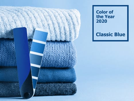 Stack of sweaters and color fun palette in classic blue 2020 color. Color of year 2020 concept for fashion and clothing industry.