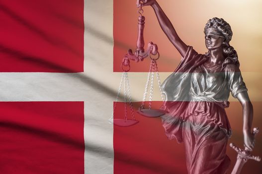 Figure of Justice holding scales and sword on a Danish flag in a conceptual image of law and order and impartiality