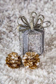 Silver present and two gold pincecone in the snow
