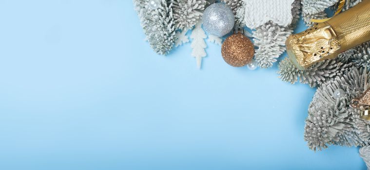 Frosted fir tree twigs and Christmas decorative bauble balls on blue background with copy space for text template flat lay top view design