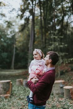 Little daughter riding father on shoulders.