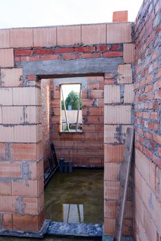 Interior of a Unfinished Red Brick House Walls under Construction without Roofing.
