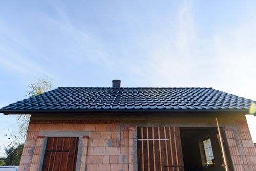 Exterior of a Unfinished Red Brick garage under Construction with roof and windows