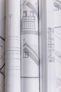 White family paper house, house projects plan and blueprints in the background. Minimalistic and simple concept, style. Horizontal orientation. View from above.