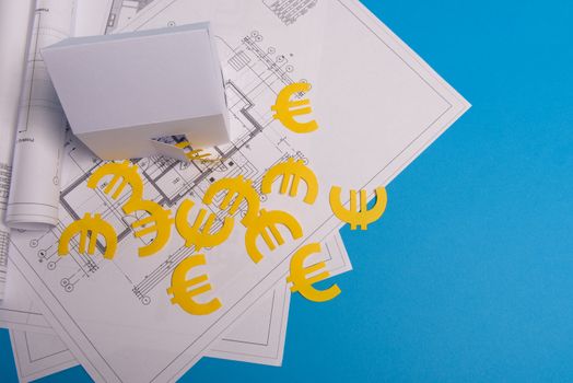 Paper skyscrapers , euro money, house projects plan and blueprints on blue background paper. Minimalistic and simple concept, style. Horizontal orientation. View from above.