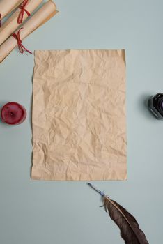Raven feather, inkwell and old yellowed paper on red background. Copy space. Old letter.