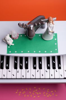 white toy piano with paper notes. music piano concept. view from above. White, black and yellow music notes.