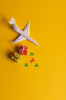 Group of paper plane in one direction and with one individual pointing in the different way on yellow background. Christmas ttrip. Presents and gifts